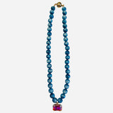 Turquoise beaded necklace with rectangular crystal charm and iridescent candy beads.