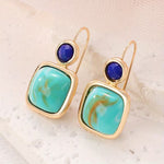 Gold dangle earrings with turquoise square stone layered over navy circle.