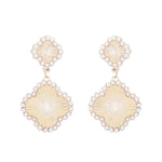 Clover dangle earrings with textured design and pearl center accent, two inch length.