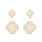 Clover dangle earrings with textured design and pearl center accent, two inch length.