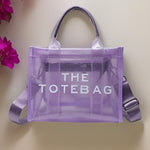 A purple, transparent tote bag with 'THE TOTE BAG' text printed on it.