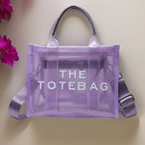 A purple, transparent tote bag with 'THE TOTE BAG' text printed on it.