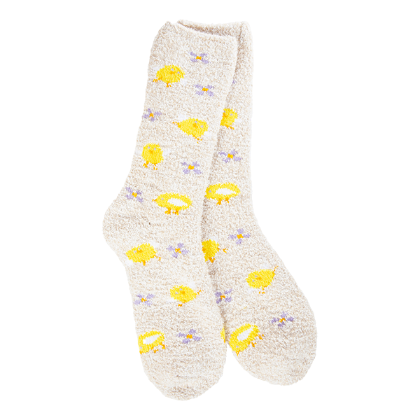 A pair of plush, soft cream-colored crew socks with a repeating pattern of bright yellow fried eggs and tiny purple flowers.