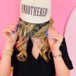 Cream canvas hat with camo bill and embroidered Unbothered lettering in bold casual style