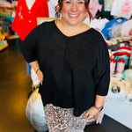 Black waffle knit V-neck top with raw front seam, 3/4 sleeves, and relaxed fit.