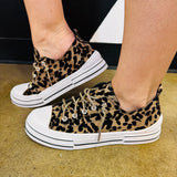 Leopard print sneakers with sparkling rhinestone laces, white rubber toe, and chunky platform sole.