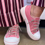 Pink canvas sneakers with sparkling rhinestone laces, silver eyelets and white rubber toe caps.