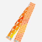 Reversible scarf tie with luggage tag patterns and floral geometric motifs in yellow, orange, pink, coral.
