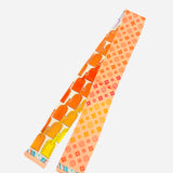 Reversible scarf tie with luggage tag patterns and floral geometric motifs in yellow, orange, pink, coral.