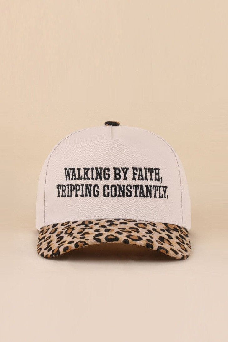 Two-tone leopard hat with Walking By Faith Tripping Constantly embroidered saying.