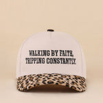 Two-tone leopard hat with Walking By Faith Tripping Constantly embroidered saying.