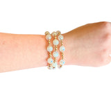 Water resistant white beaded elastic bracelet with pearlescent beads and gold spacer accents.