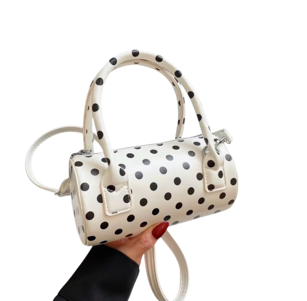 White polka dot crossbody bag with adjustable strap and top handles.