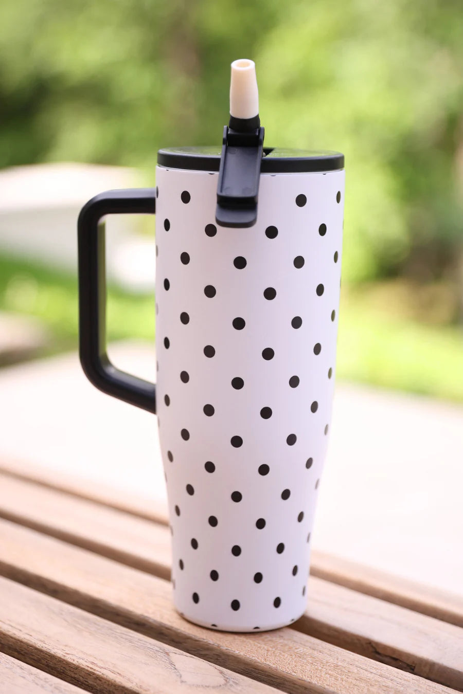 White 40oz tumbler with black polka dots, flip straw lid, and handle.