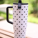 White 40oz tumbler with black polka dots, flip straw lid, and handle.