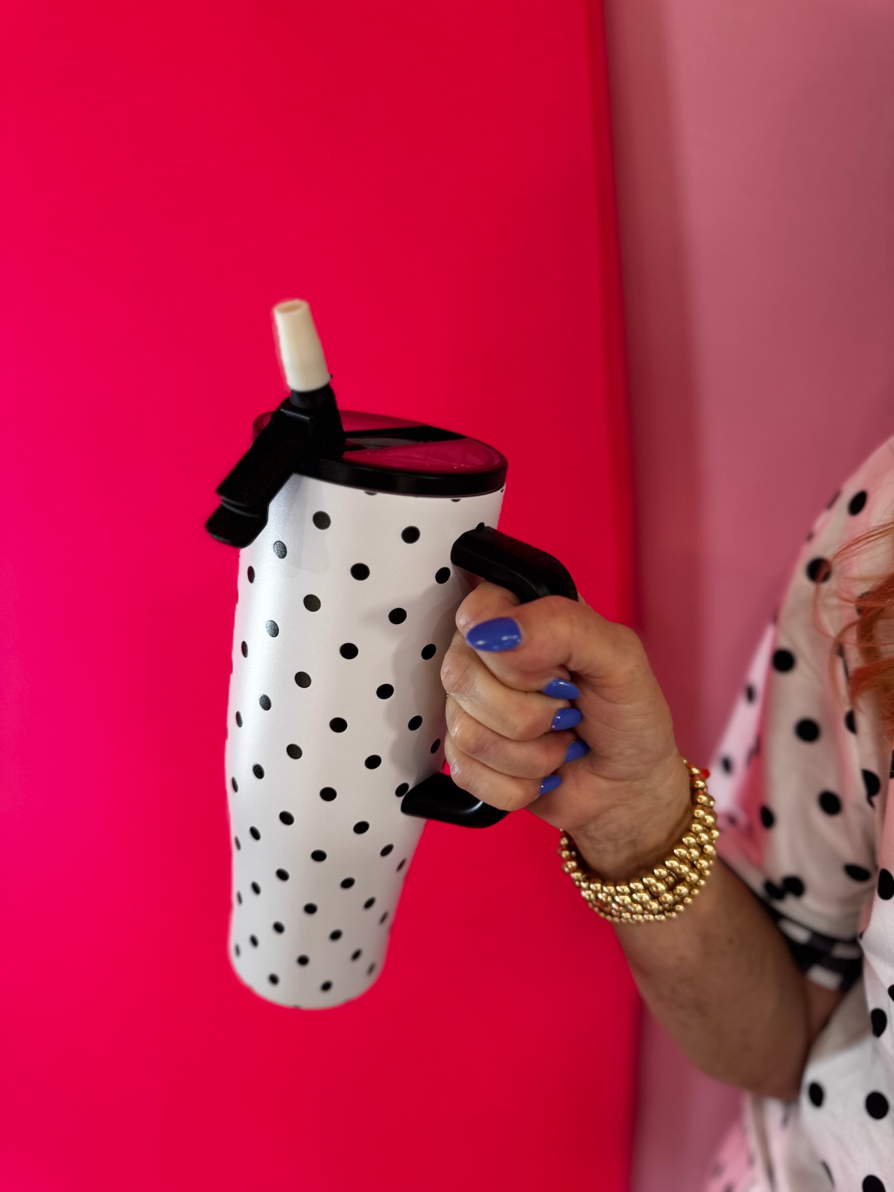 White 40oz tumbler with black polka dots, flip straw lid, and handle.