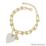 White studded heart charm bracelet on gold chain, water resistant.