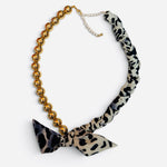 Gold ball bead necklace with leopard print scarf, tied bow accent, and adjustable chain.