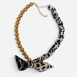 Gold ball bead necklace with leopard print scarf, tied bow accent, and adjustable chain.