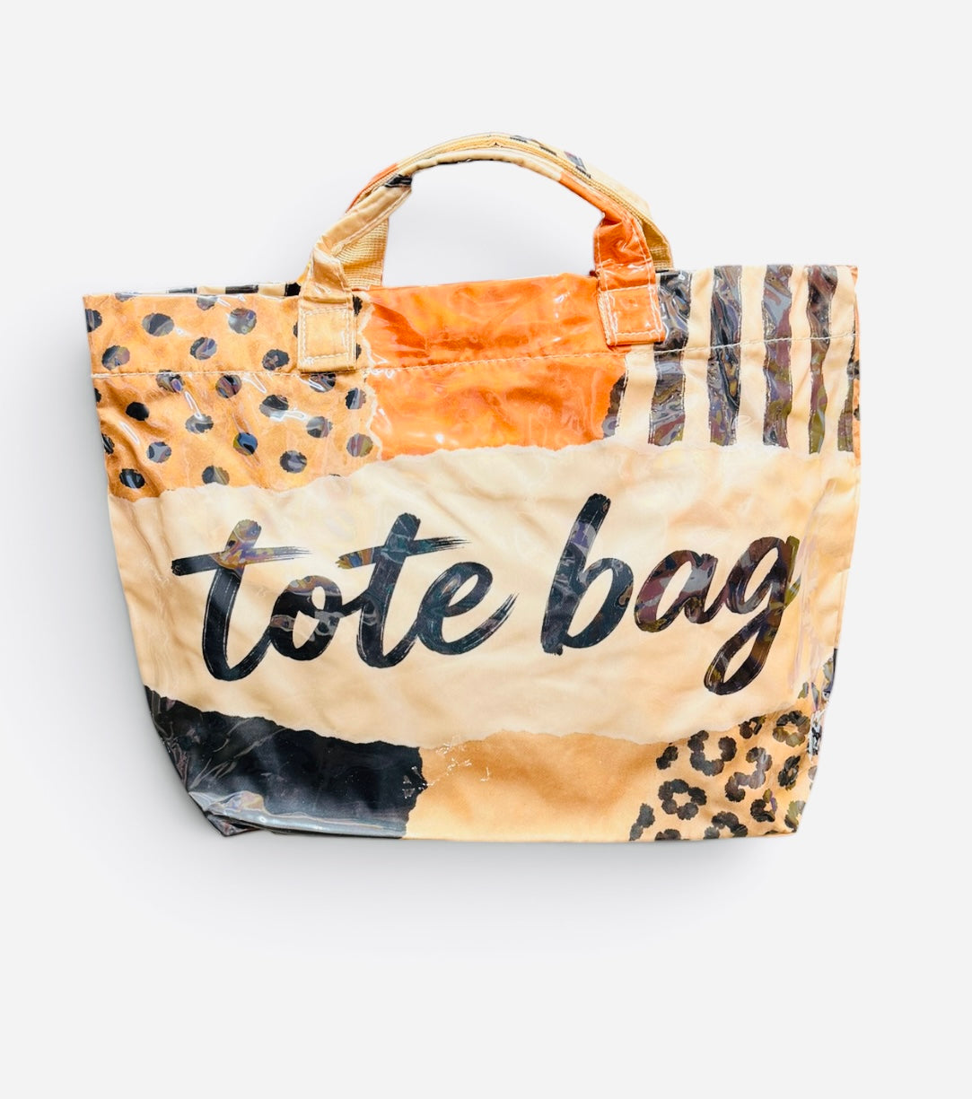 PVC tote bag with orange, cream, black, and leopard patchwork and bold lettering.