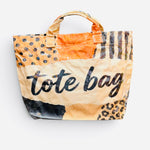 PVC tote bag with orange, cream, black, and leopard patchwork and bold lettering.