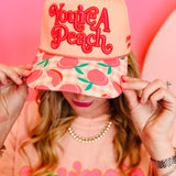 Peach canvas hat with You’re A Peach embroidery and colorful peach print brim.