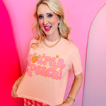 Blush pink crop tee with retro peach graphic and playful lettering on Comfort Colors shirt