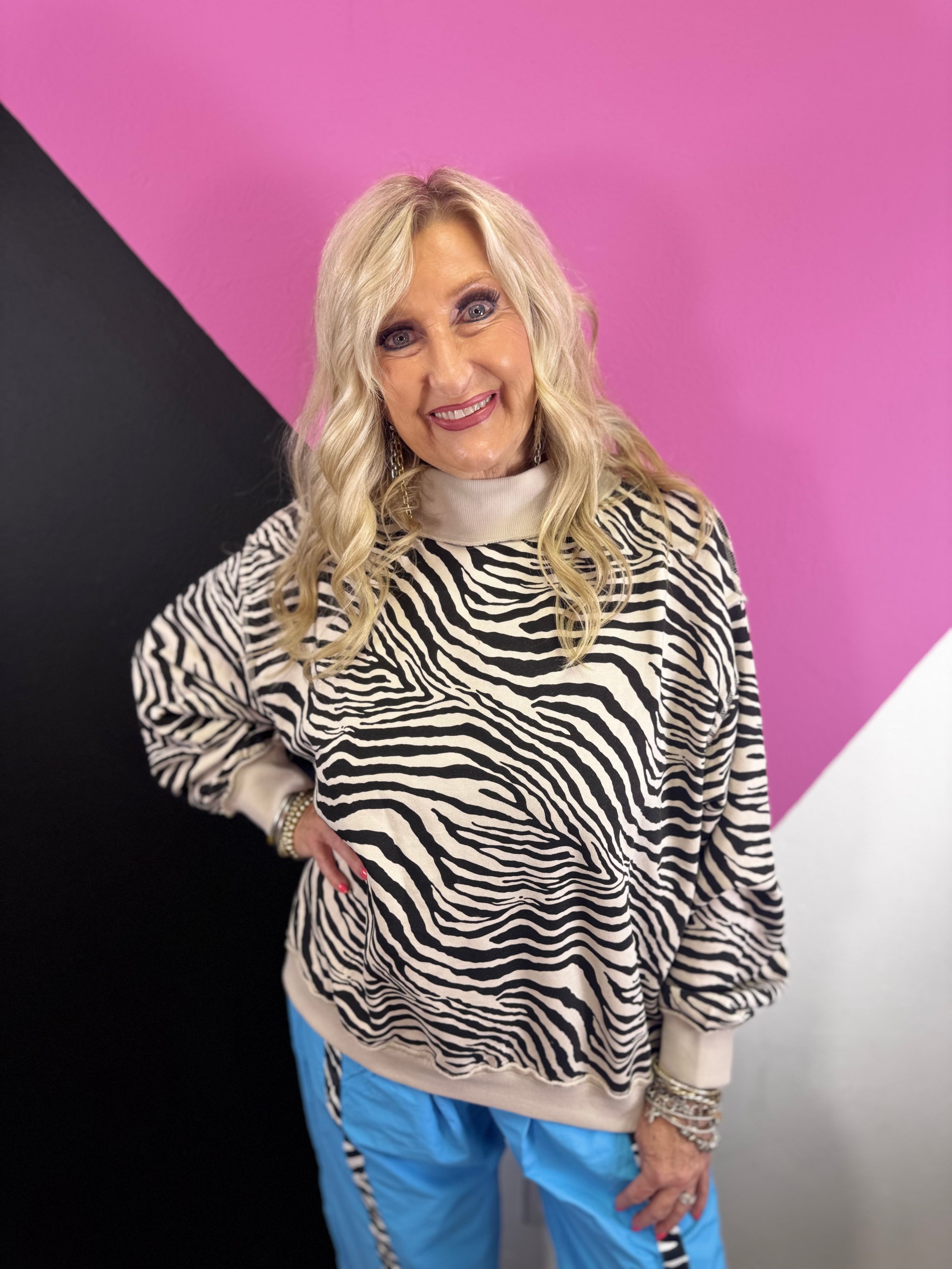 Zebra print oversized sweatshirt with mock neckline, drop shoulders and ribbed trim.
