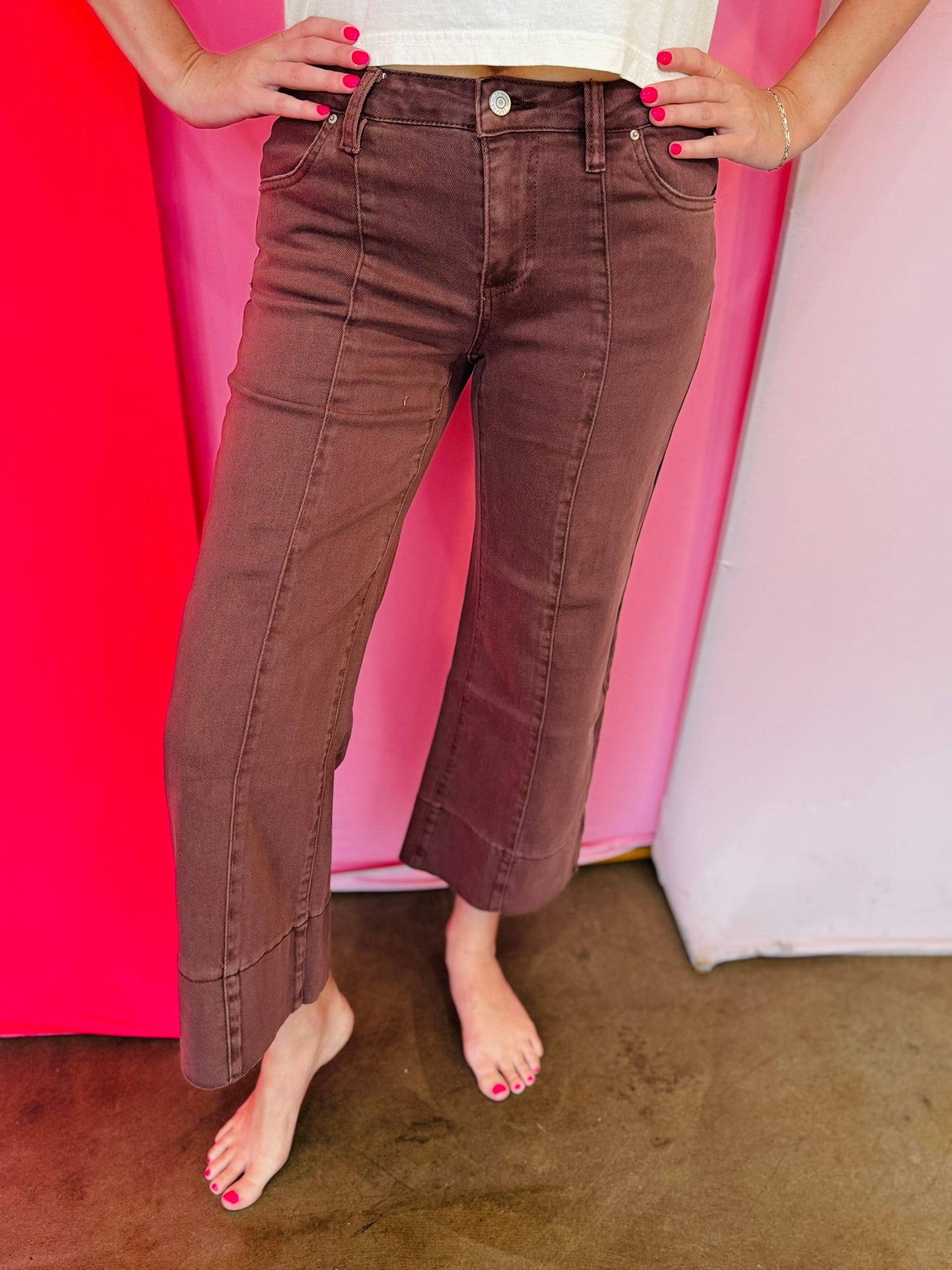 Brown wide leg cropped jeans with front pintuck detail and relaxed fit.