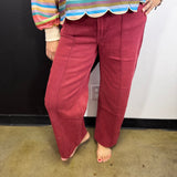 Dark burgundy high-rise wide leg jeans with front pintuck seam detailing.