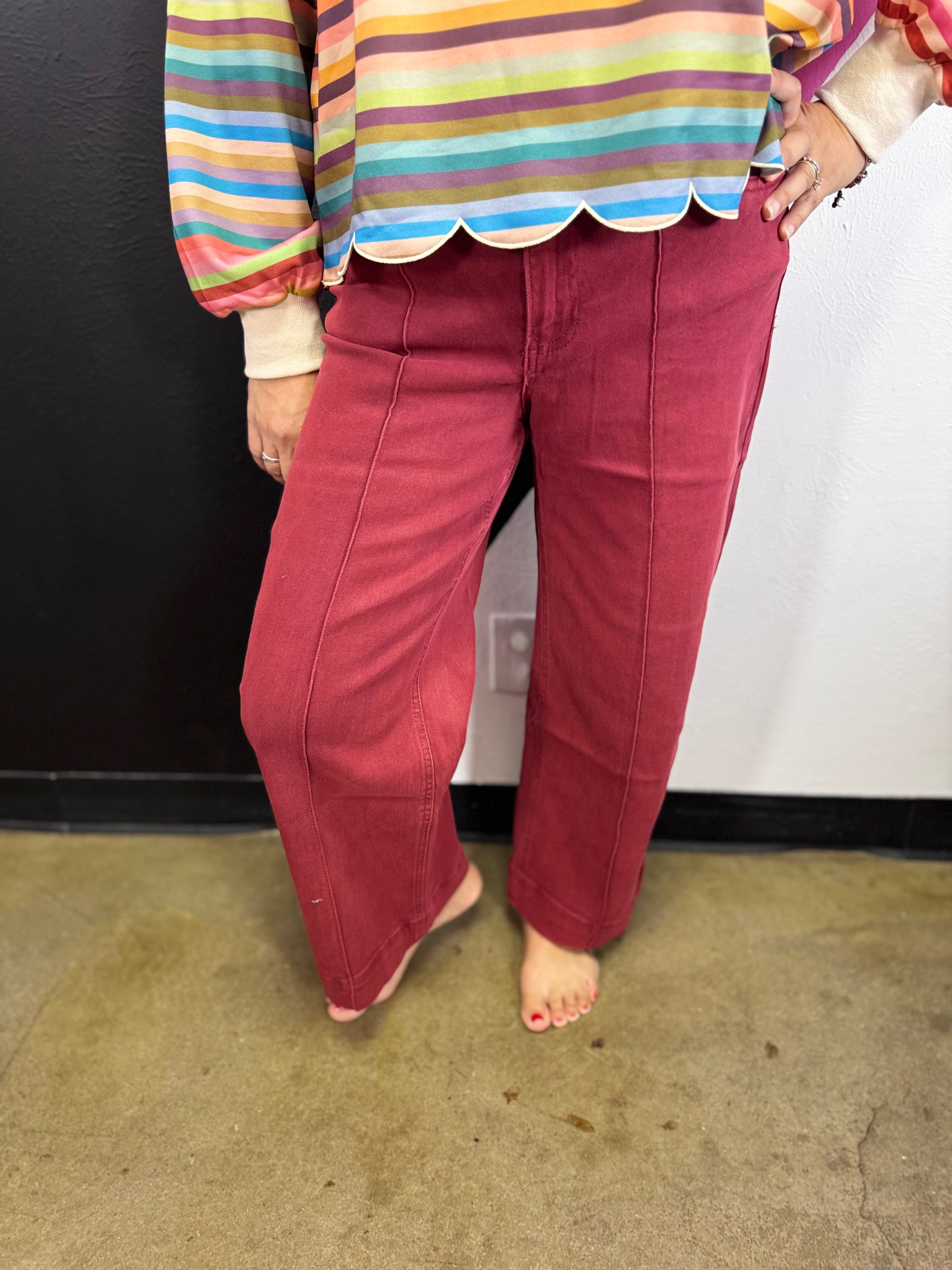 Dark burgundy high-rise wide leg jeans with front pintuck seam detailing.