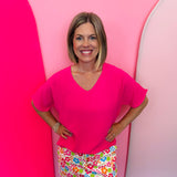 Hot pink lightweight woven V-neck top with short sleeves and relaxed fit