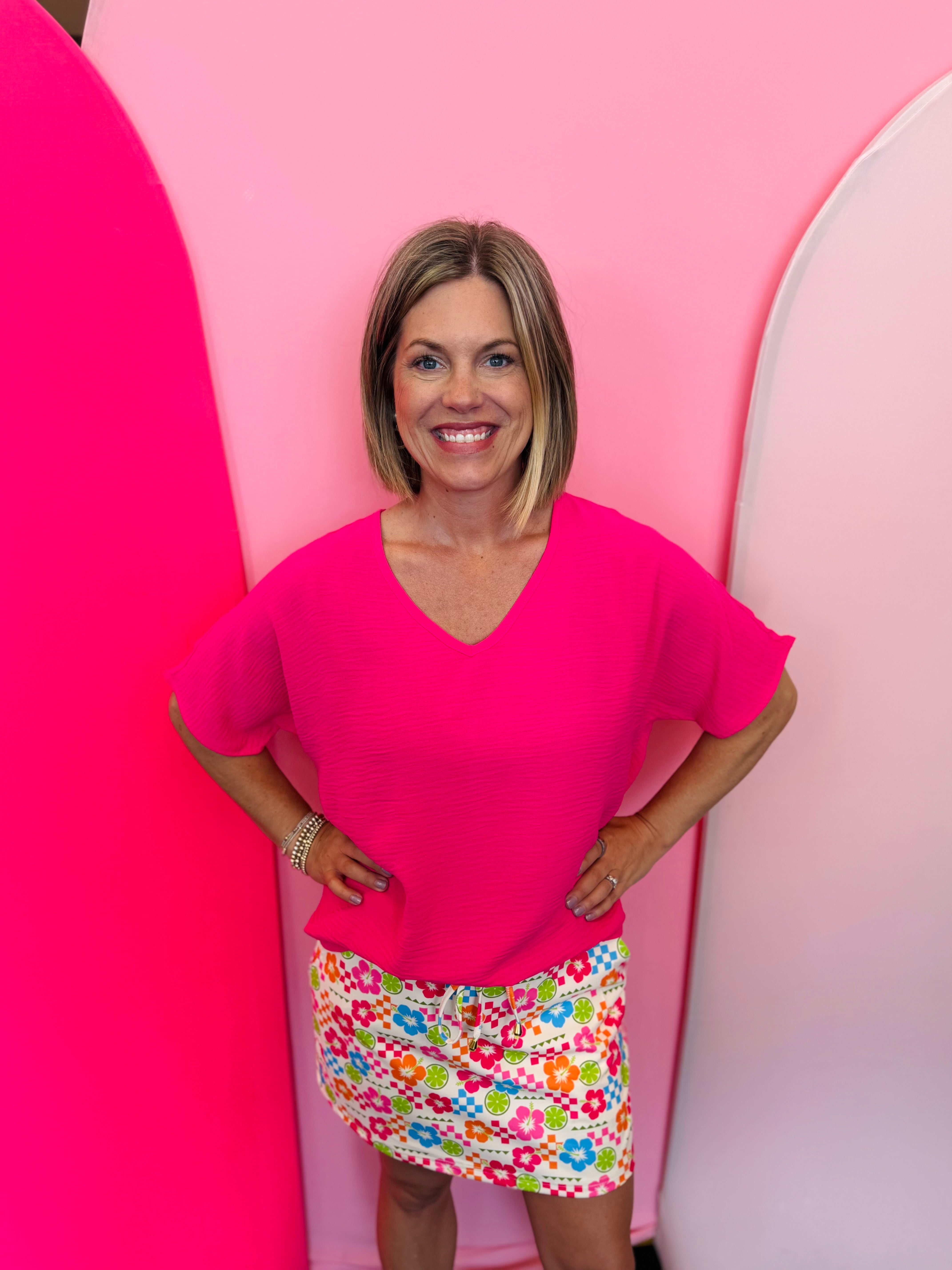 Hot pink lightweight woven V-neck top with short sleeves and relaxed fit
