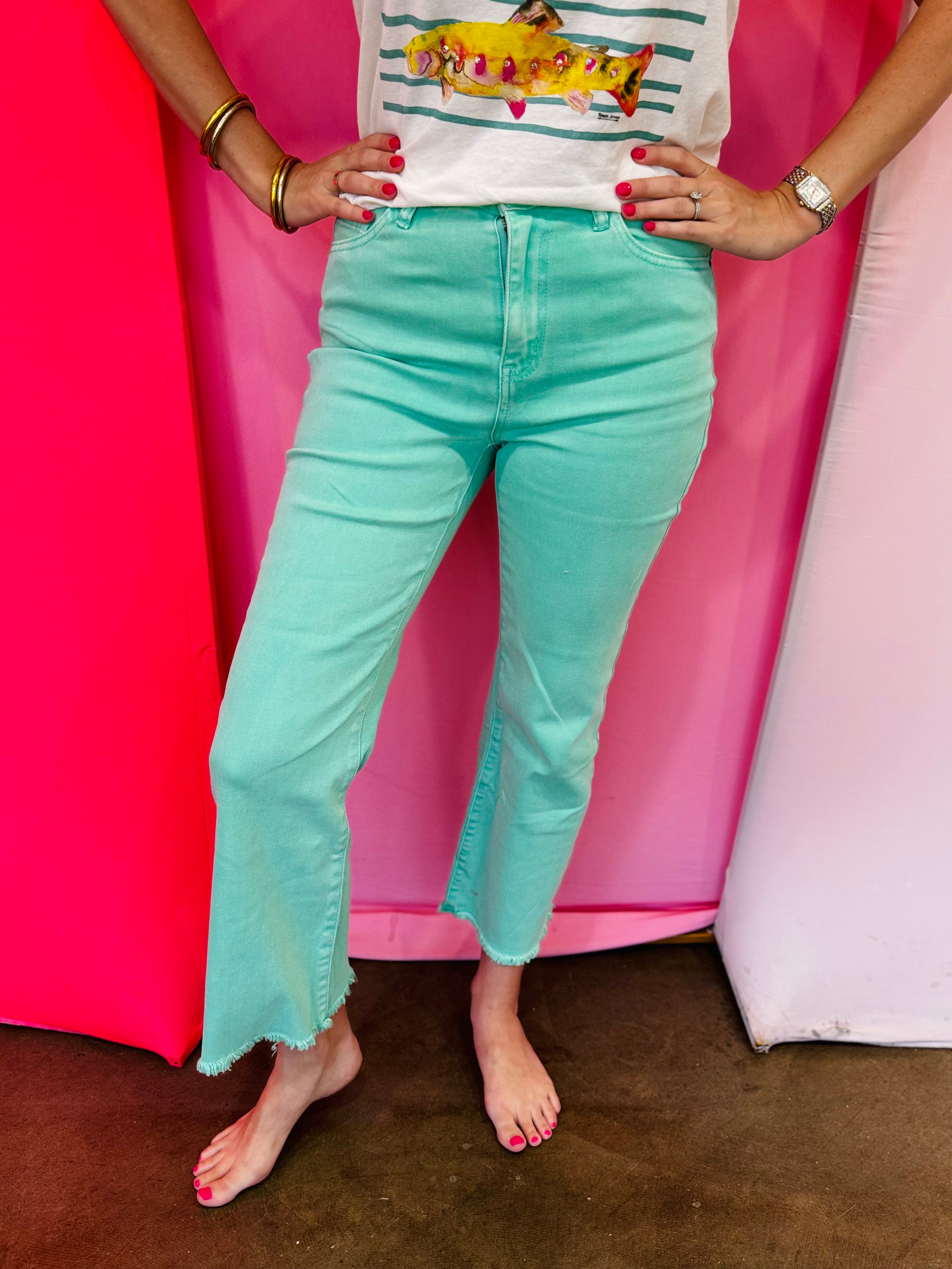 Mint cropped bootcut jeans with frayed hem and high-rise fit.