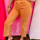Orange cropped bootcut jeans with frayed hem and high-rise fit.
