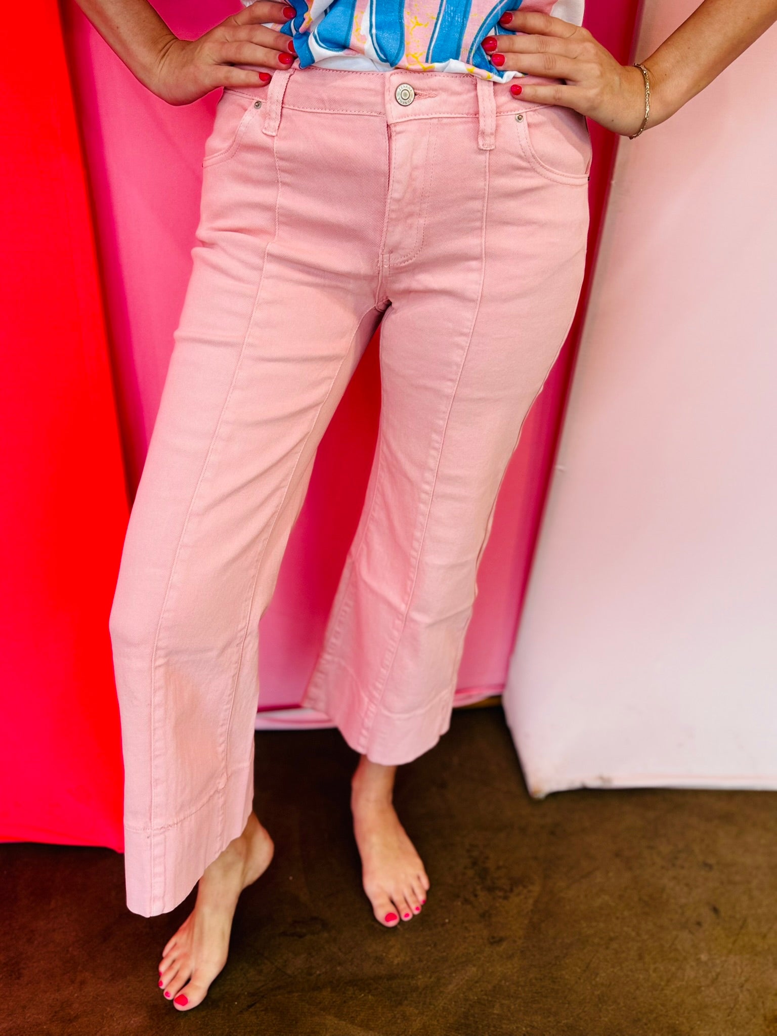 Pink wide leg cropped jeans with front pintuck detail and relaxed fit.