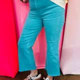 Turquoise cropped bootcut jeans with frayed hem and high-rise fit.