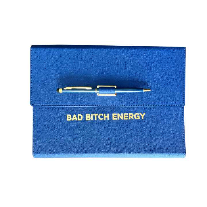 Blue clutch journal folio and calendar with 'BAD BITCH ENERGY' text and colored pen.