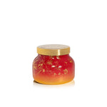 An 8oz Capri Blue Apple Cider Social Glimmer Petite Candle in cranberry red with a metallic finish.