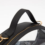 Gold hardware and top handle on a clear football-shaped crossbody bag with black trim