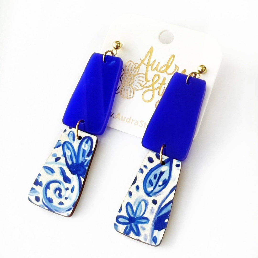 Blue and white Floral Dangle patterned earrings on a from Audra Style branding.