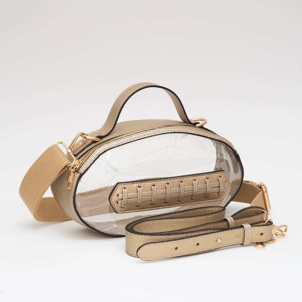Clear football-shaped crossbody bag with metallic gold trim, gold hardware, top handle, and adjustable strap, displayed flat to highlight shape and shine.