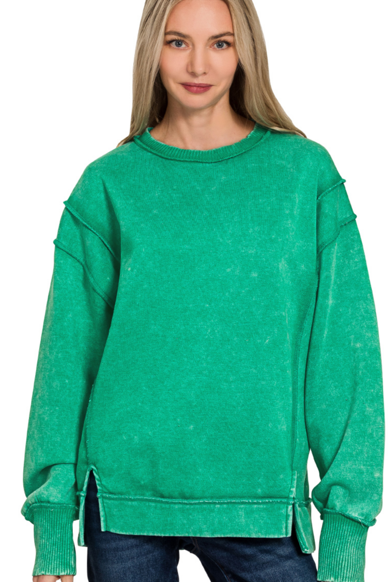 A relaxed-fit, kelly green acid wash fleece sweatshirt. The sweatshirt has visible exposed seams and a side slit at the bottom.