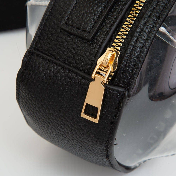 gold zipper on clear football-shaped crossbody bag with black trim