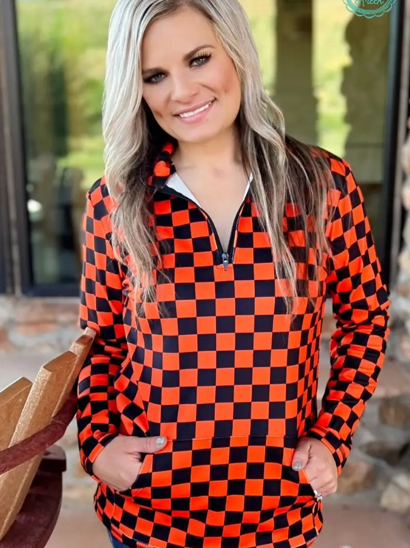 Orange and black checkered pullover with collared neckline, quarter-zip front, and kangaroo pocket, laid flat to show pattern and structure.