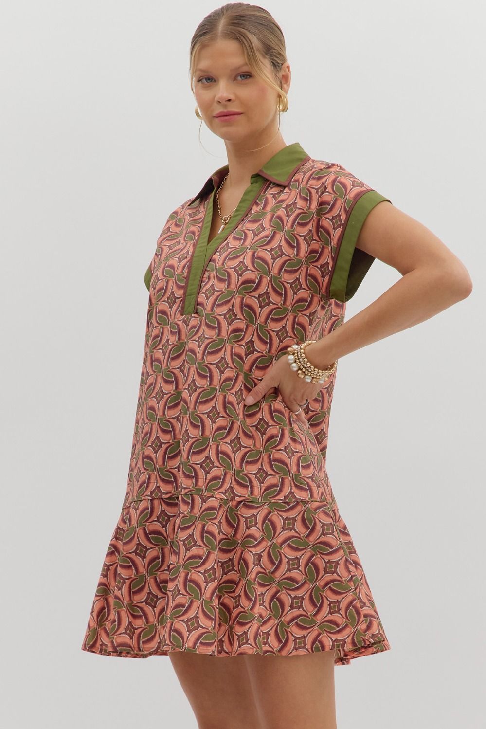 Terra cotta abstract print mini dress with green collar, ruffle hem.