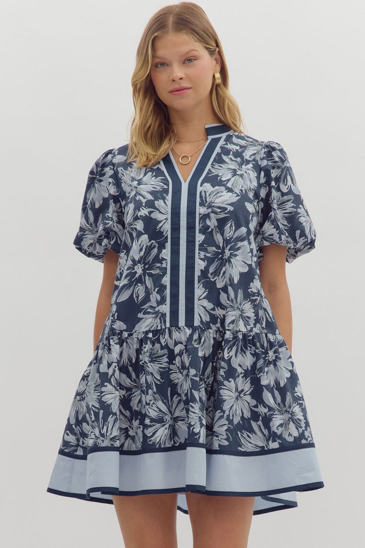 Navy floral print mini dress with white flowers, bubble sleeves, ruffle hem.