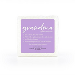 A soap-infused sponge with the word "Grandma" printed in the center, shown with rich, creamy lather.
