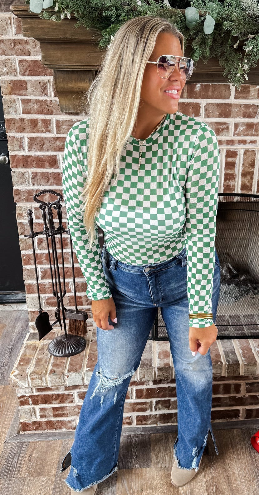 Green and white checkered mesh top with crew neck and long sleeves.
