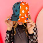 Orange and gray polka dot half design snapback hat with curved brim.